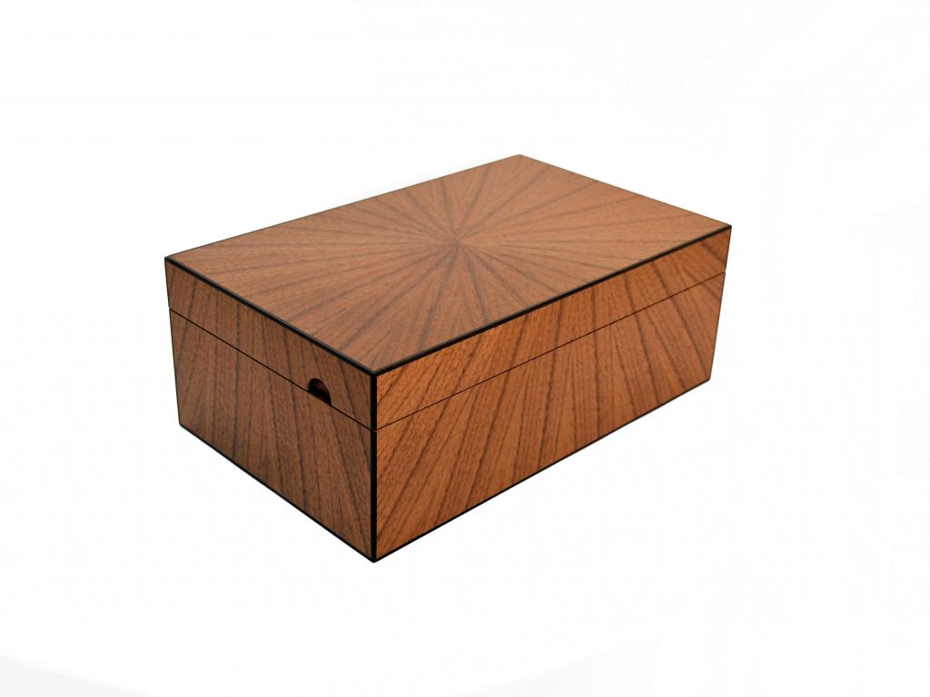 A jewellery box in walnut with a sunburst flowing from the top down the sideds